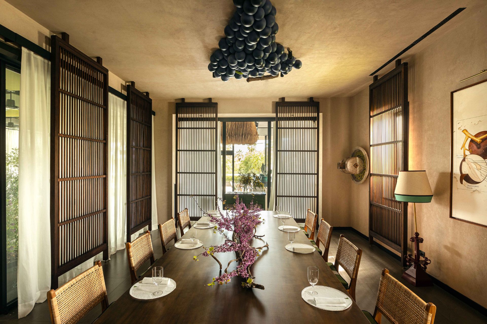 Dining room with wooden furniture and a light feature resembling a bunch of purple grapes.