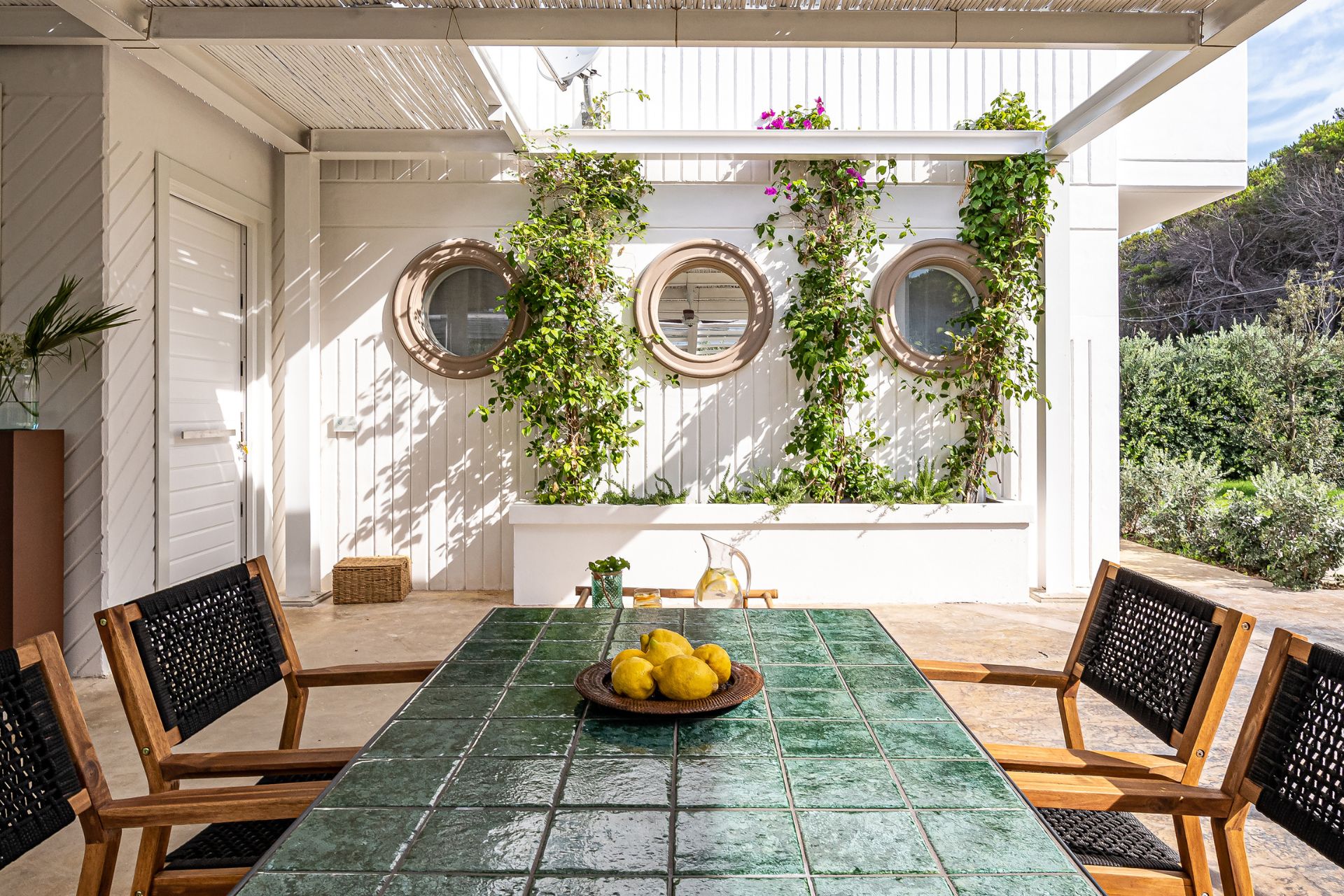 Outdoor dining area with green table and white pergola