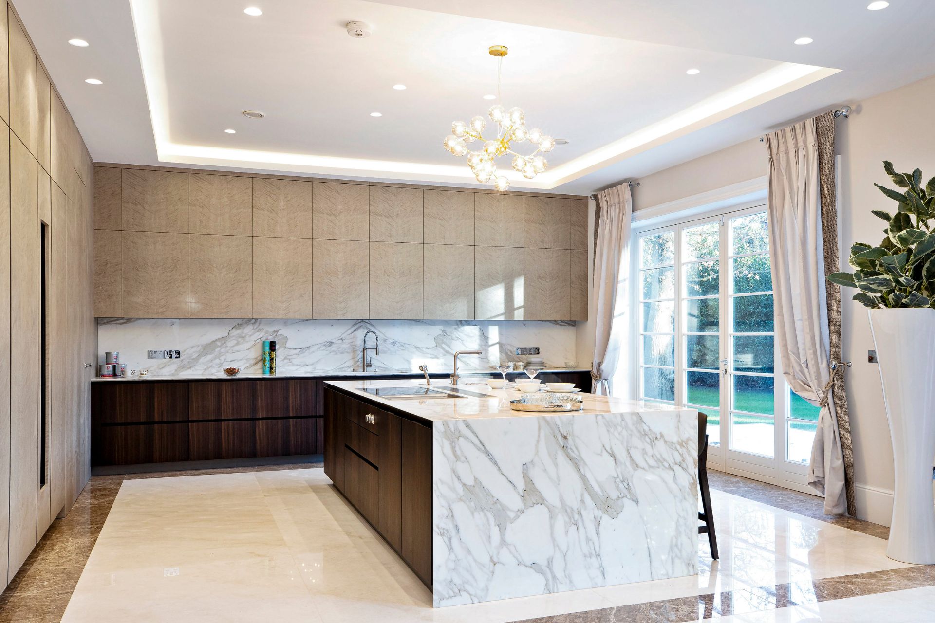 Modern kitchen with marble island and taupe cabinets
