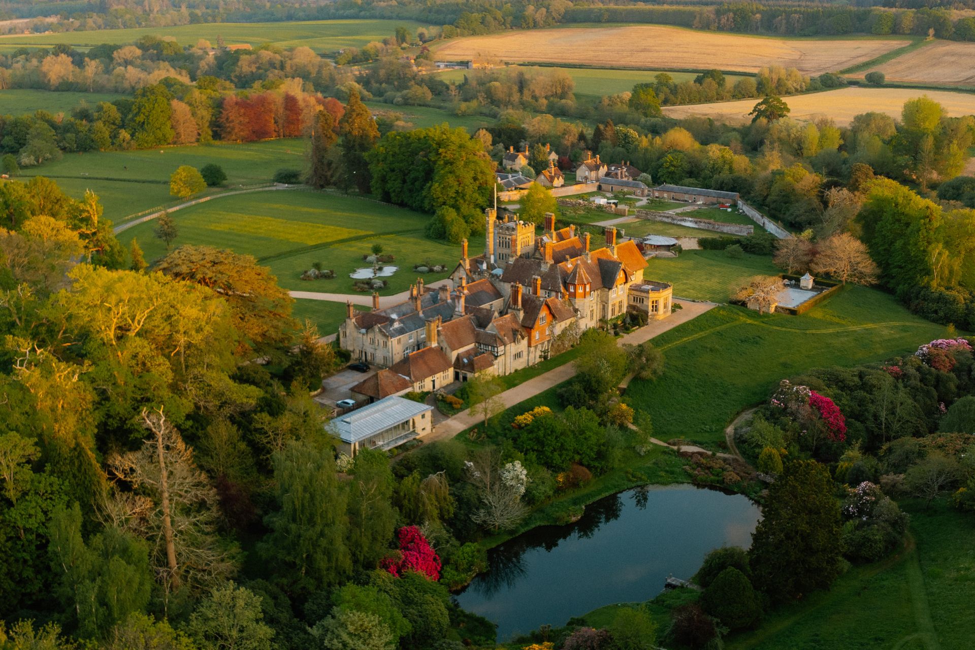 Aerial view of manor house, lake and grounds at the Cowdray Estate