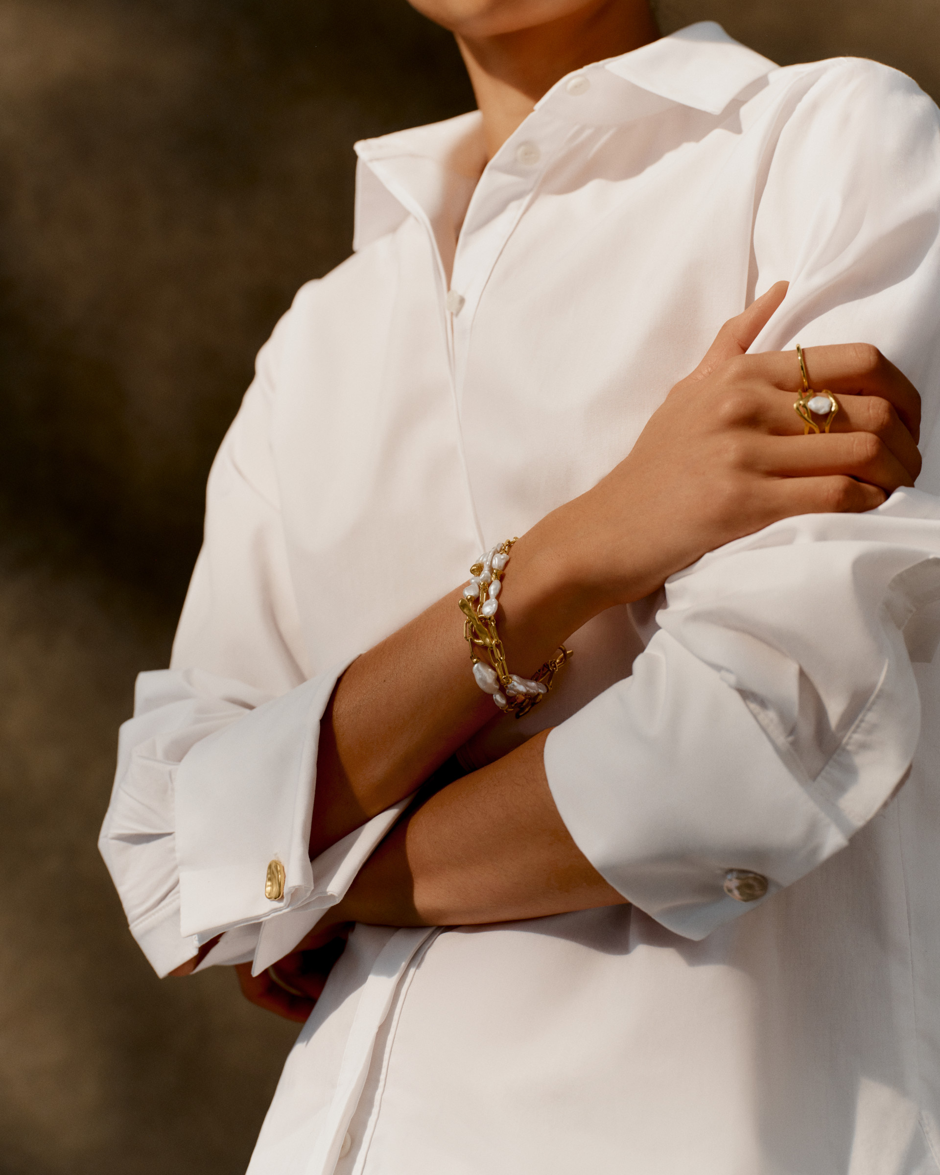 Close up of arms folded over white shirt