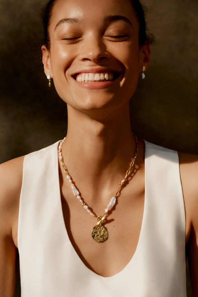 Woman wearing gold and pearl jewellery