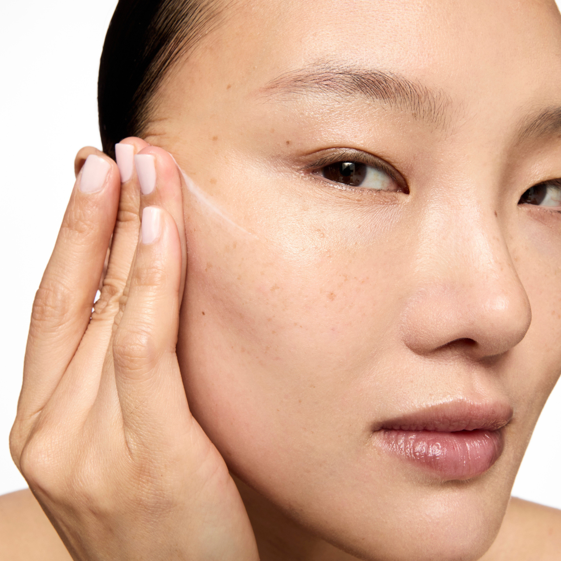 Woman putting skincare on her face
