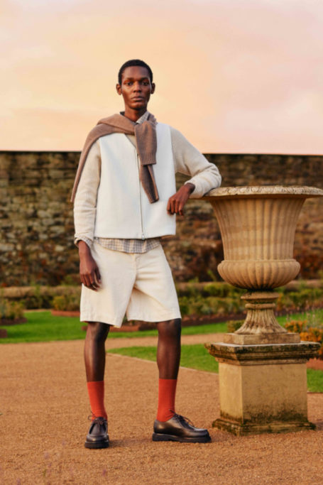 Man in summer clothes leaning on stone urn