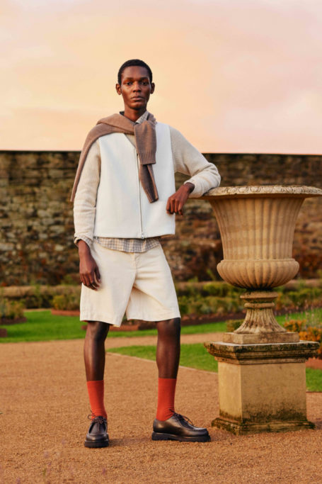 Man in summer clothes leaning on stone urn