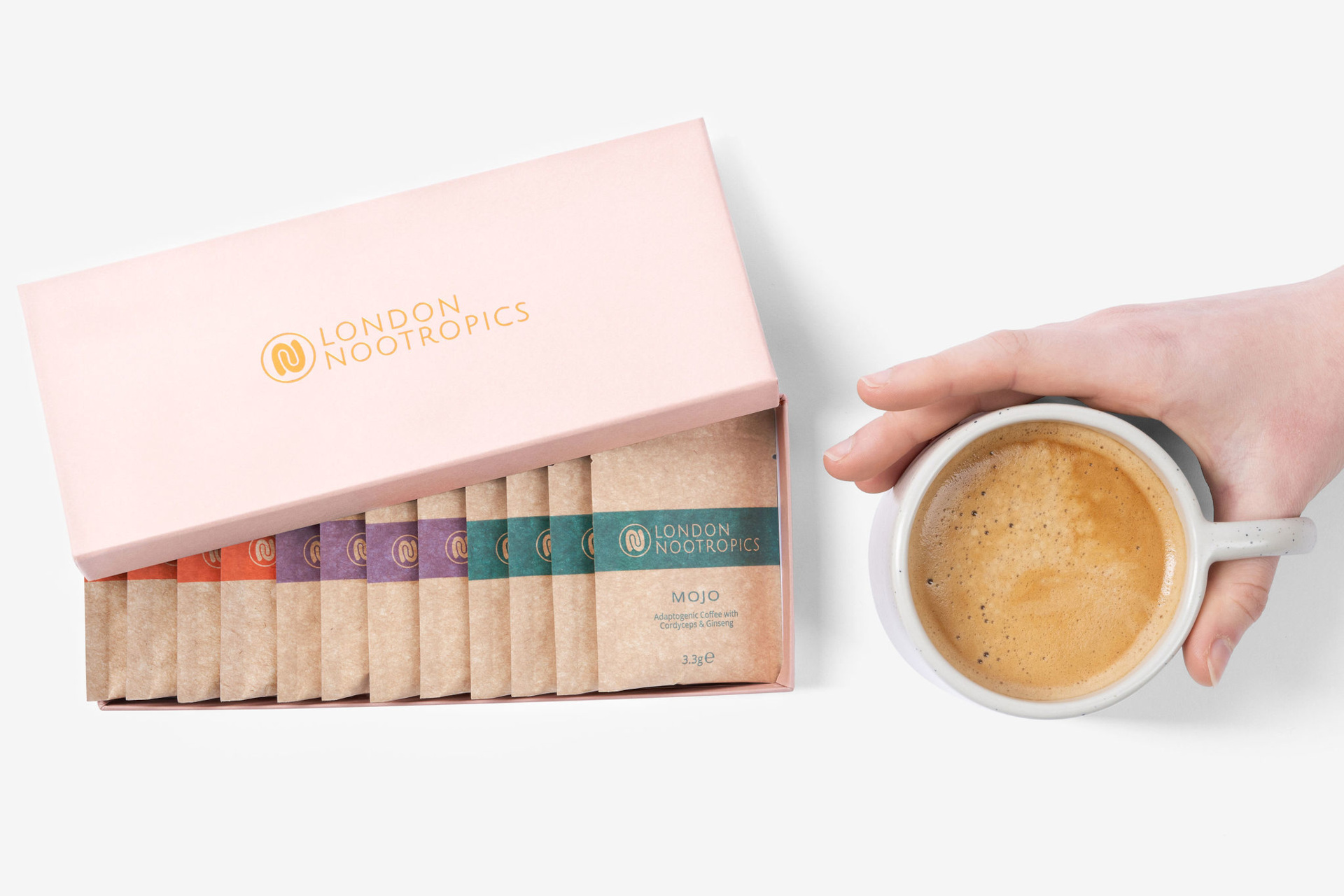 Coffee sachets in pink box next to cup of coffee