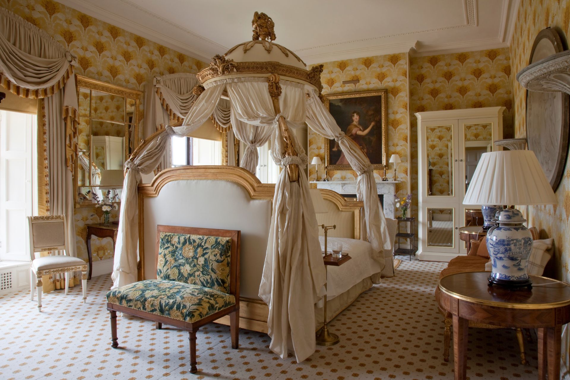 Hotel bedroom with canopy bed and floral wallpaper
