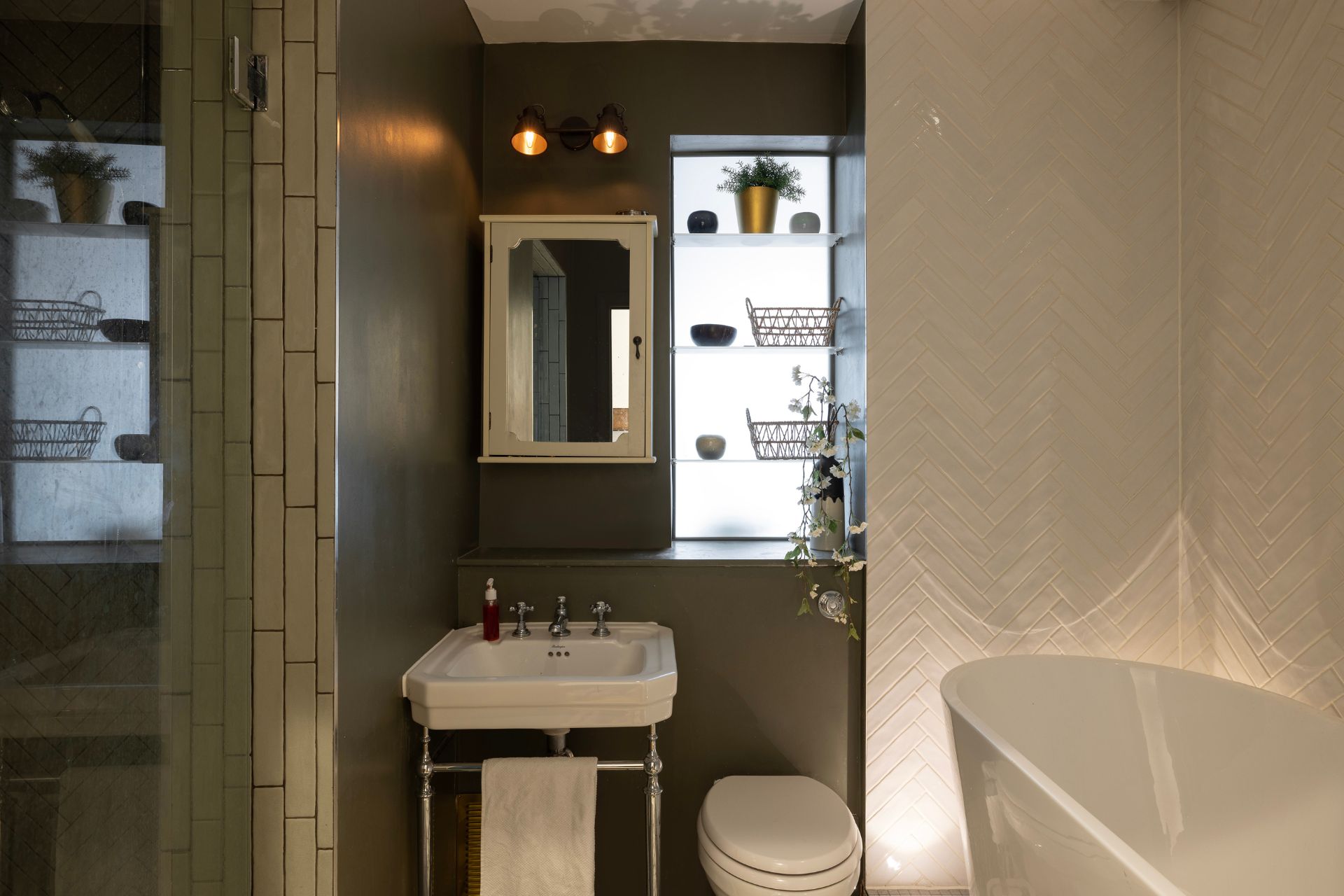 Bathroom with dark green wall and freestanding bathub.