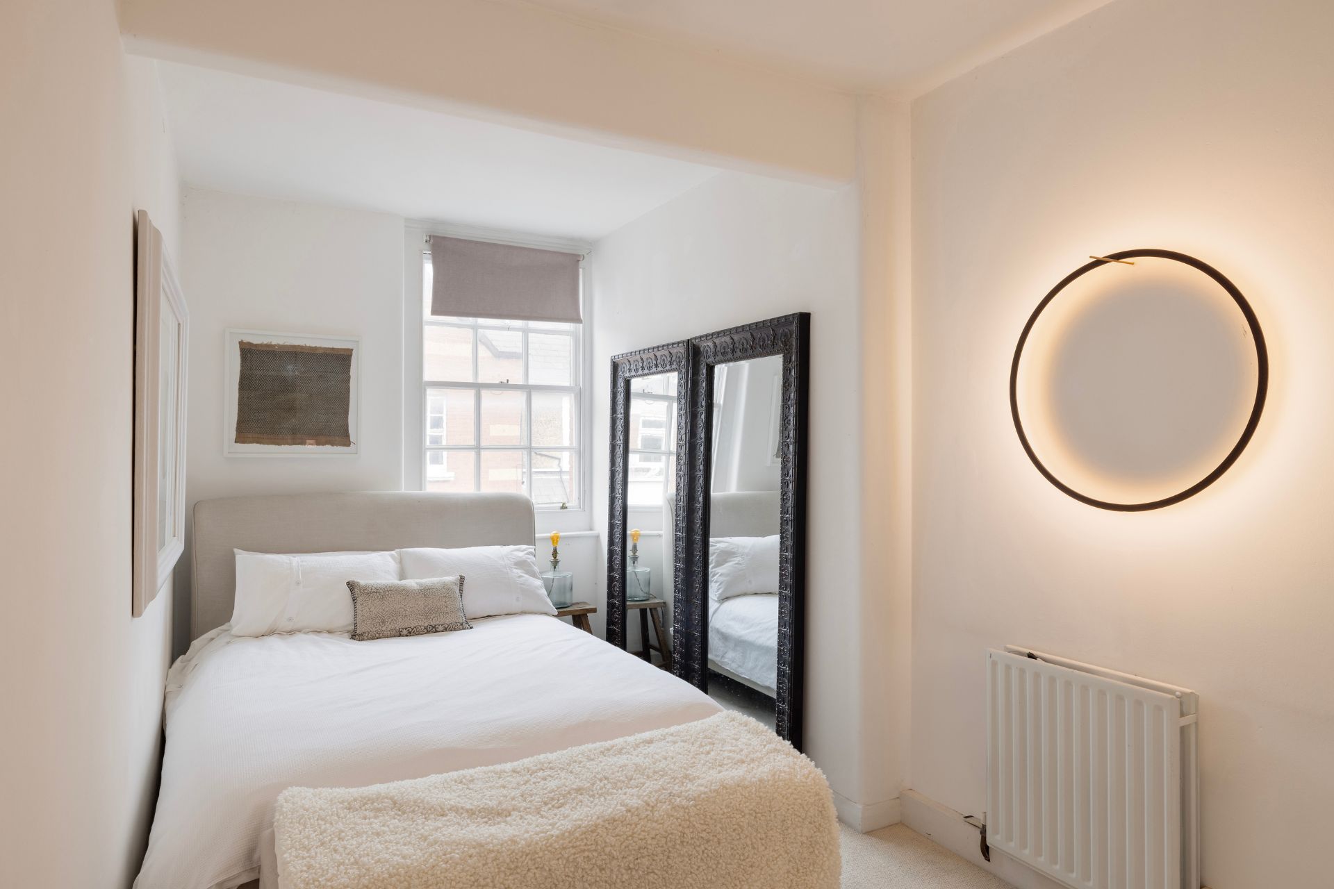 Bedroom with white walls and black full length mirror