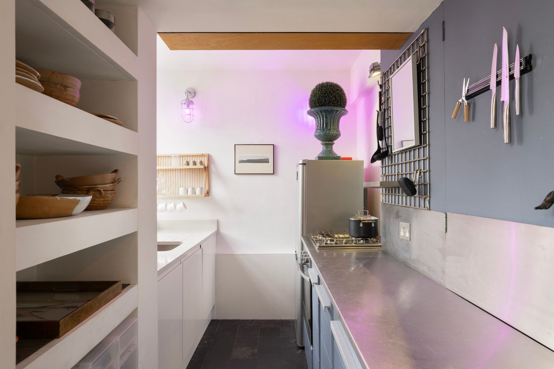 Kitchen with pale blue feature wall and aluminium worktops.