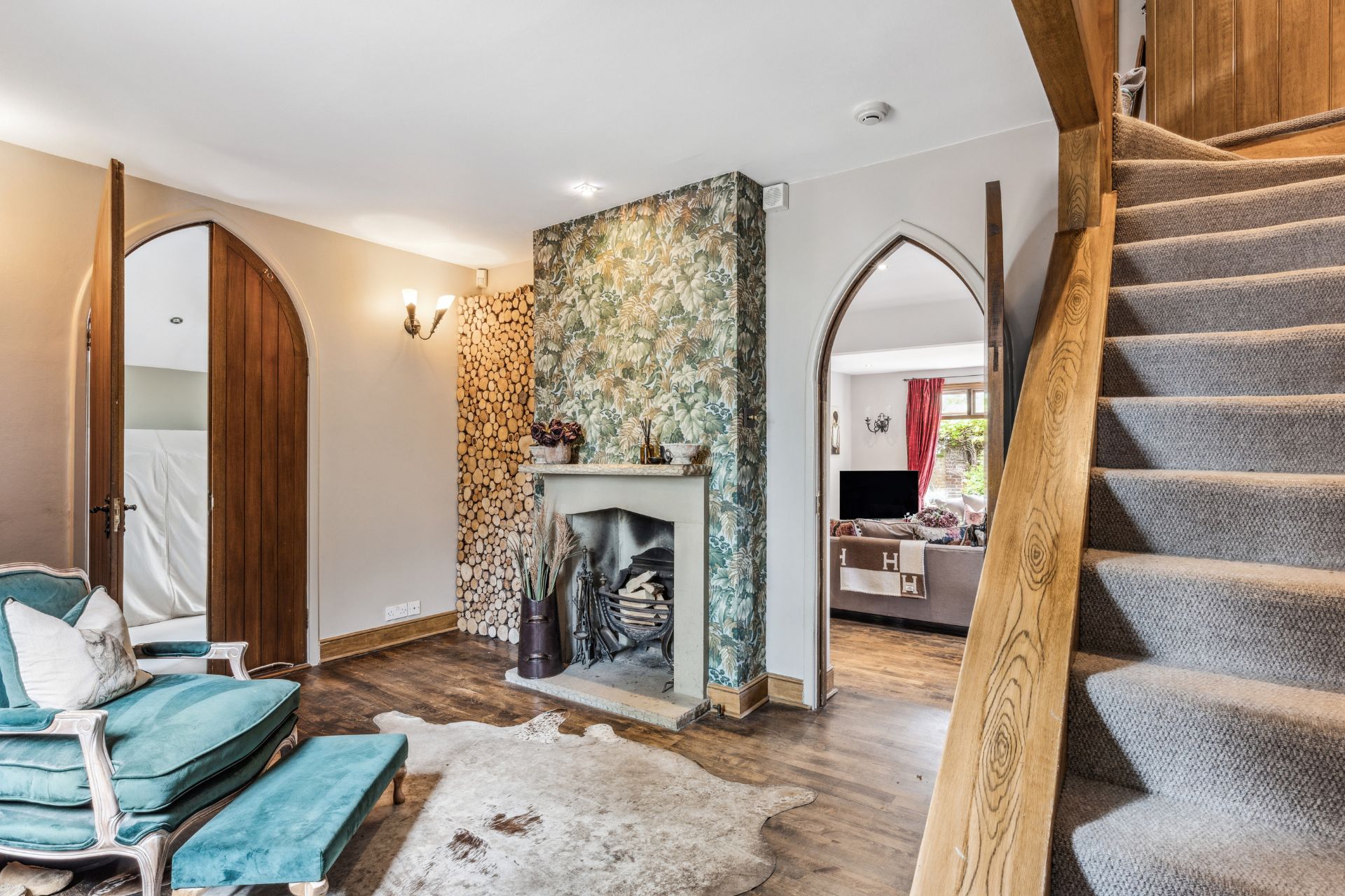 Entrance hall with arched doorway and wooden staircase