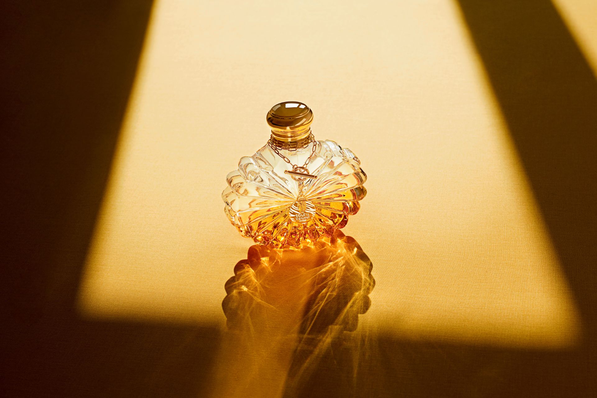 Floral perfume bottle against a yellow background
