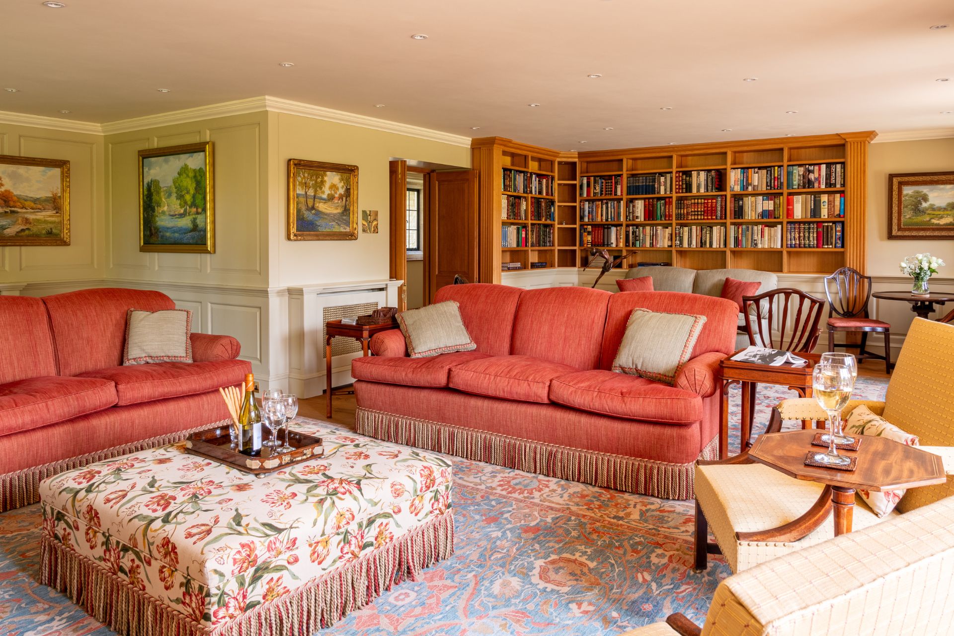 Living room with red sofas and floor-to-ceiling bookshelves.