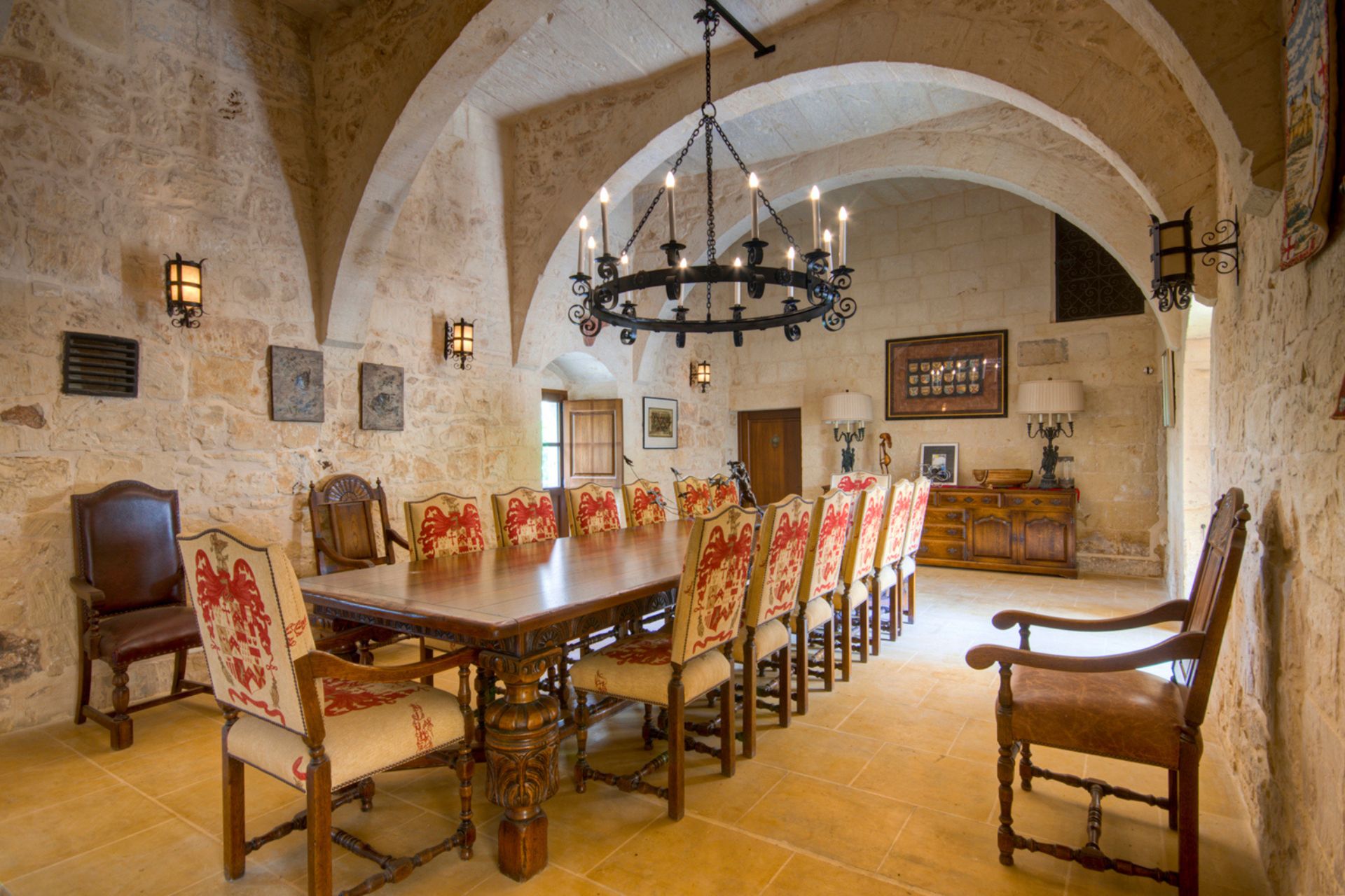 Palazzo dining room with embroidered dining chairs and an iron chandelier