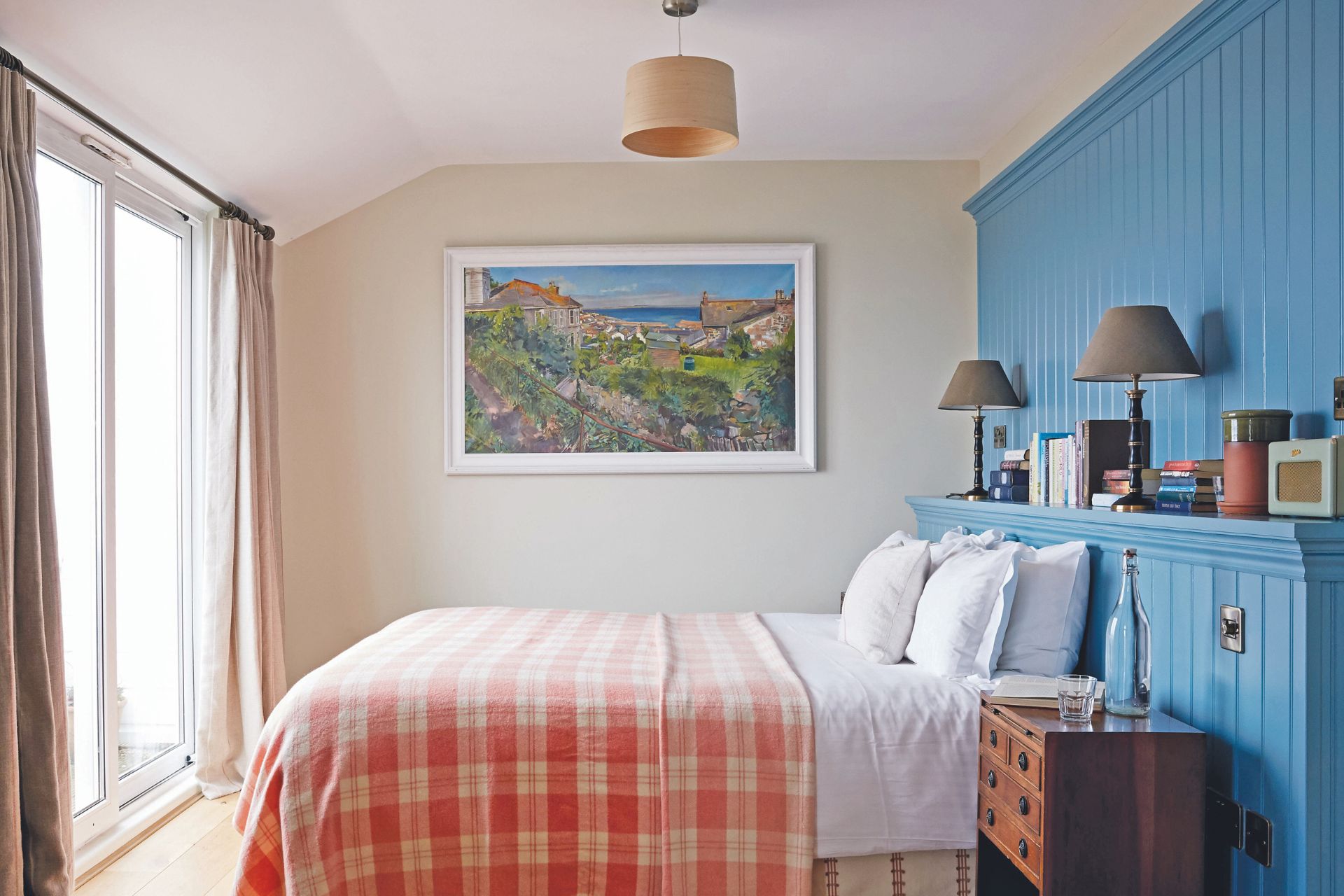 Blue panelled bedroom with pink tartan bedspread