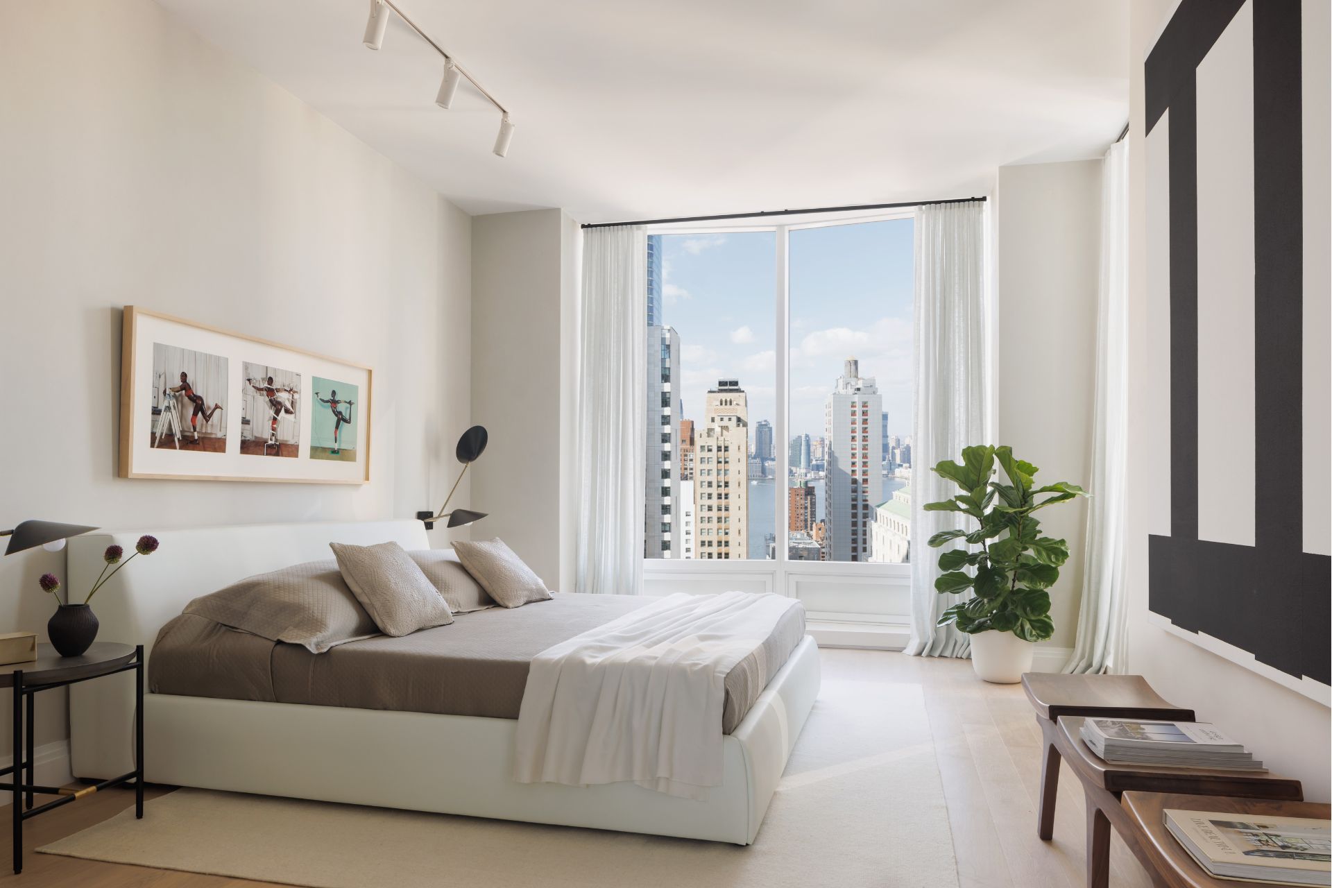 Bedroom with white divan and floor-to-ceiling windows
