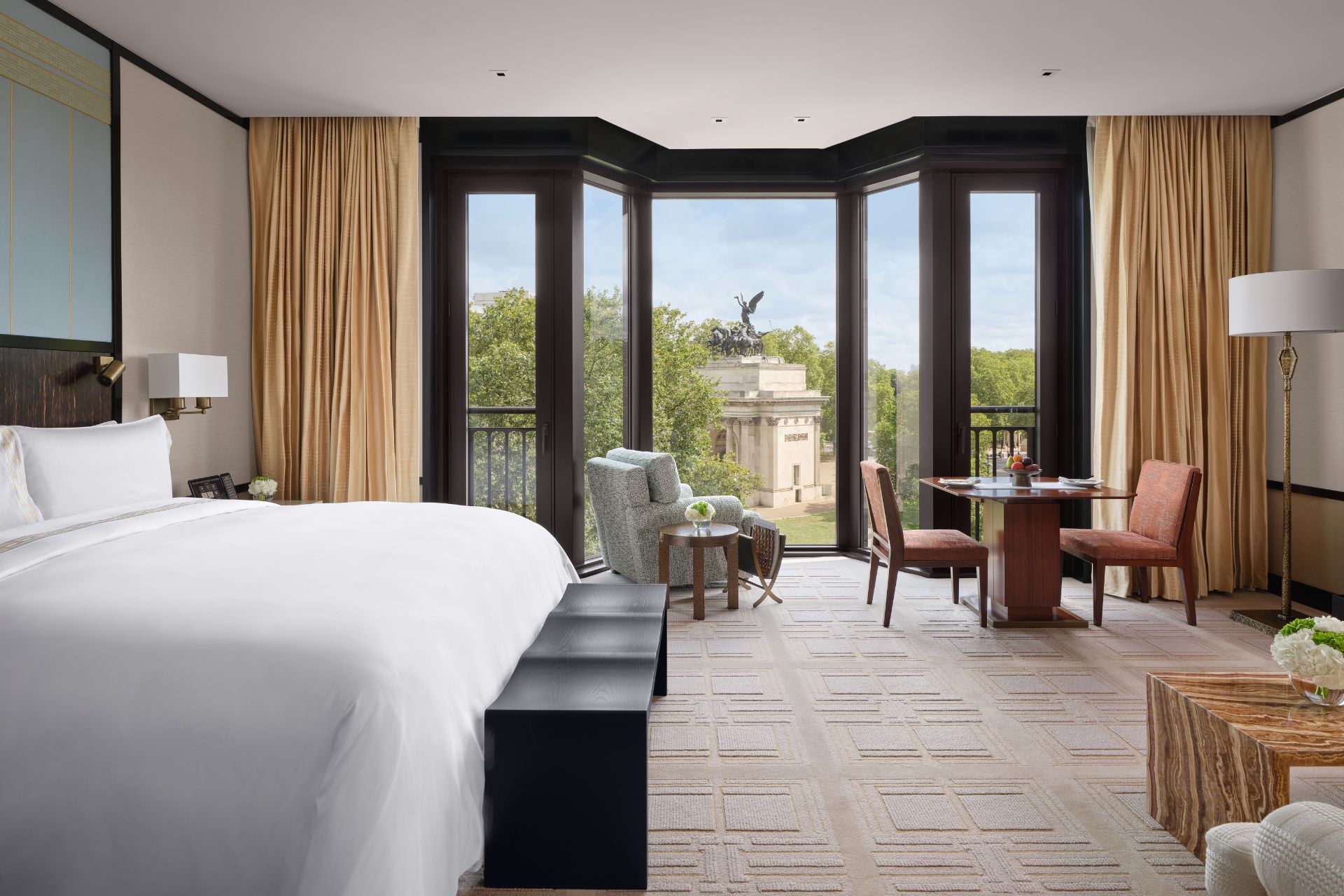 Hotel bedroom with floor-to-ceiling windows overlooking Hyde Park