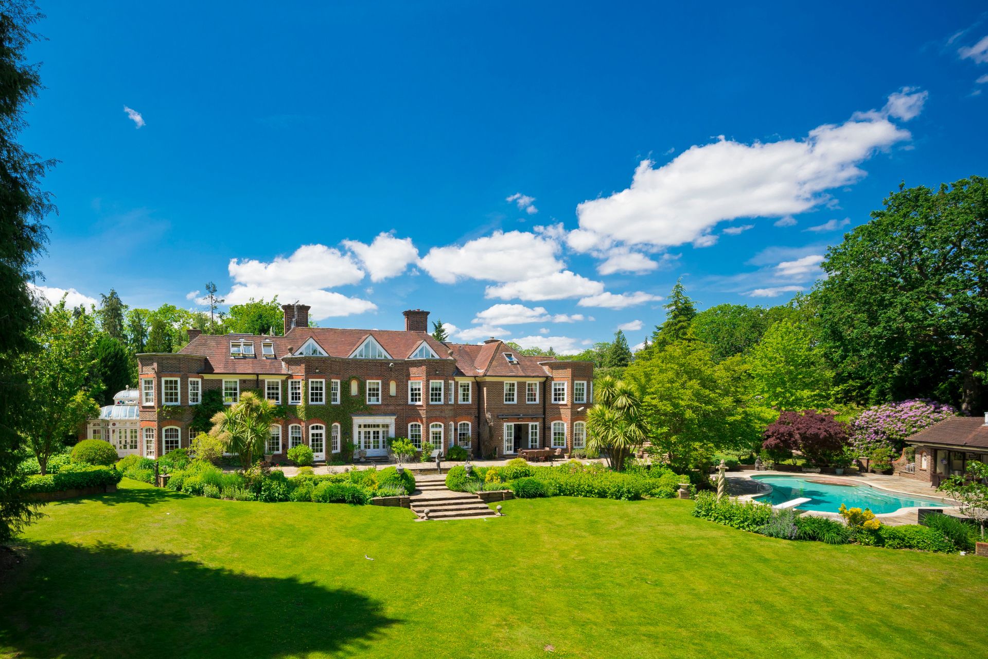 Country home with outdoor pool and large lawn.
