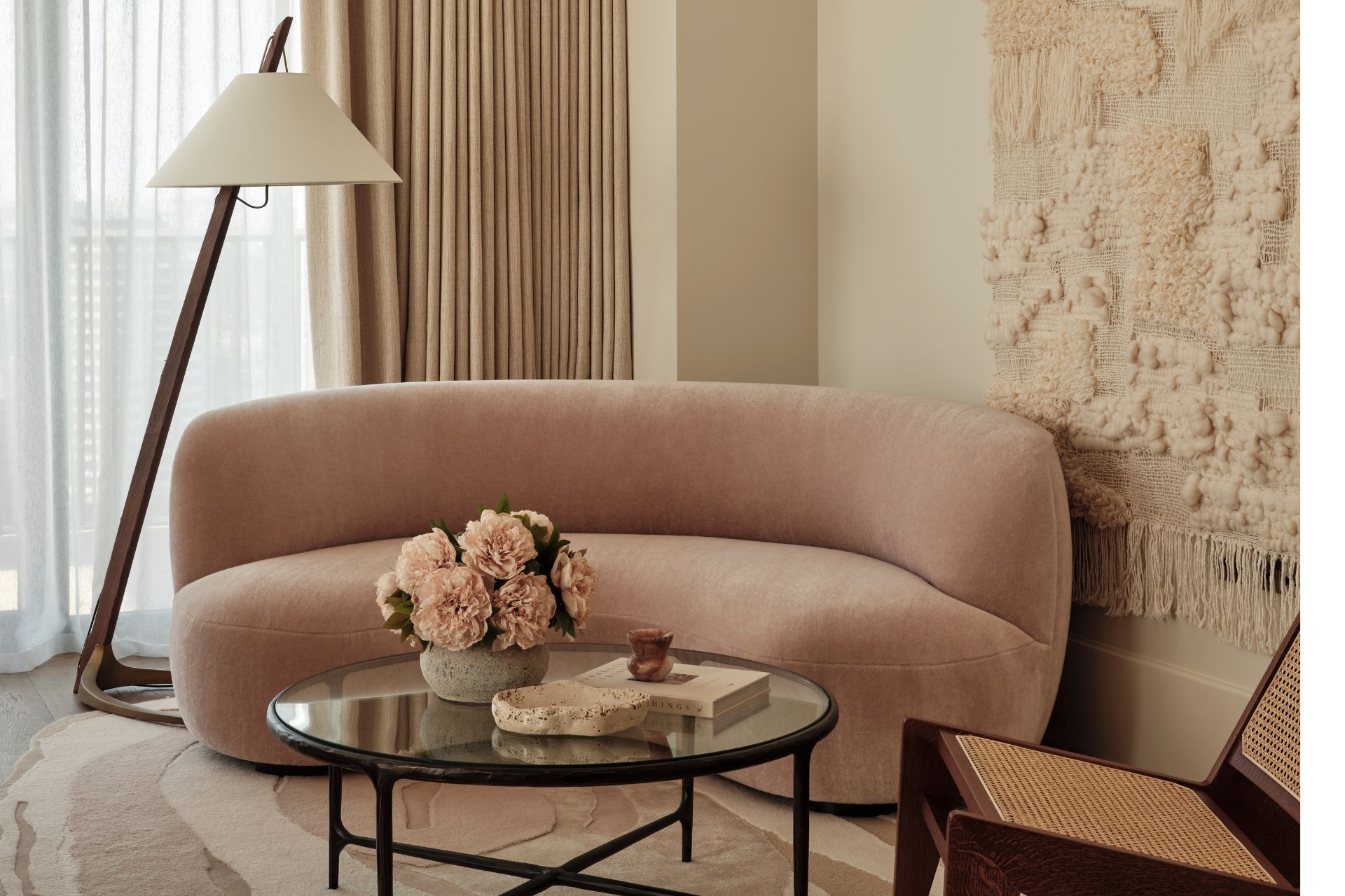 Sitting area with a blush pink curved velvet sofa