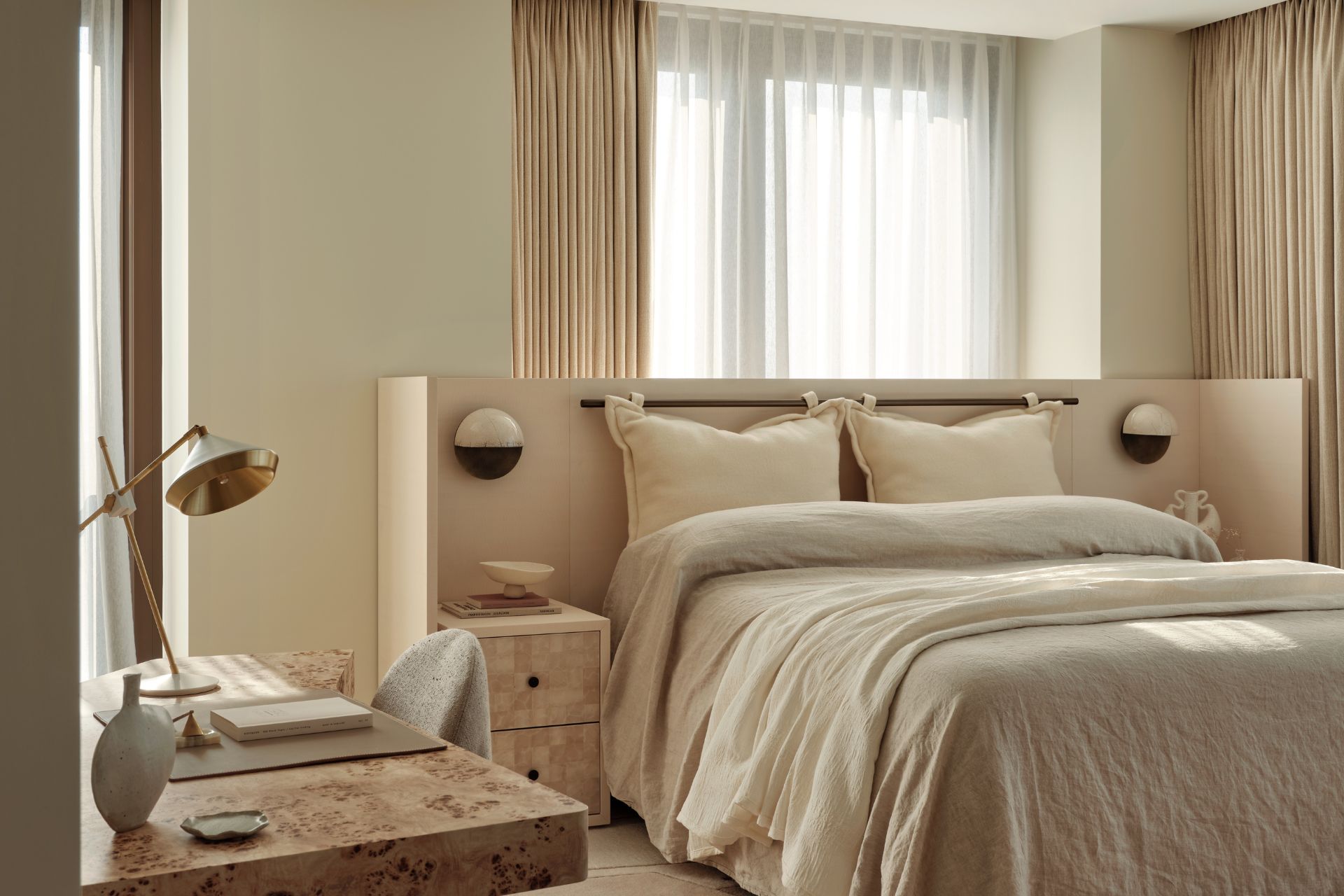 Bedroom with cream tones, white linen and sycamore tables