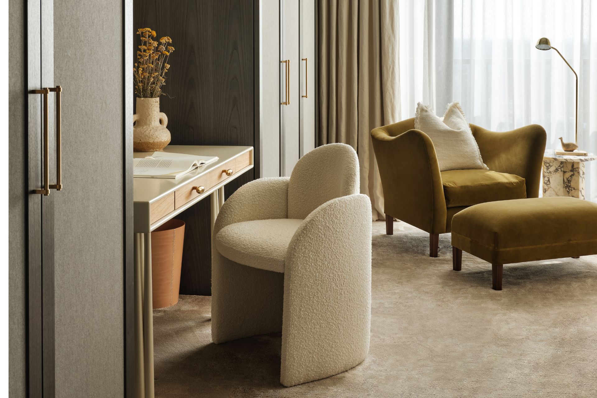 Study area with cream boucle chair, fitted wardrobes and a green velvet armchair