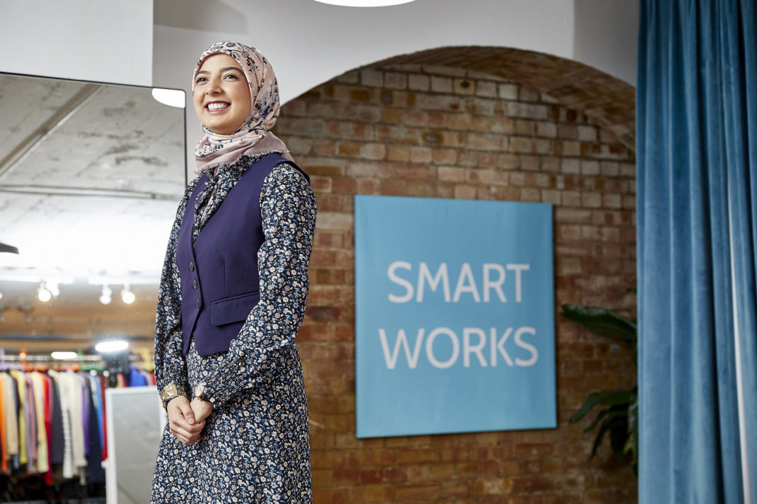 A woman stood beside the Smart Works logo