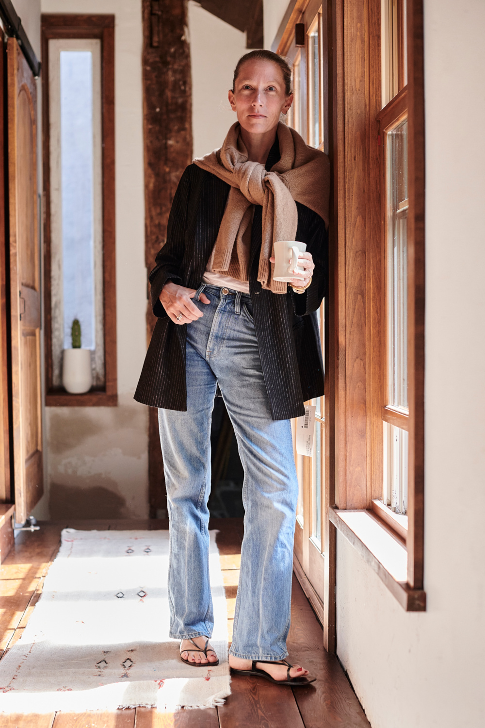Woman leaning against wall in hallway