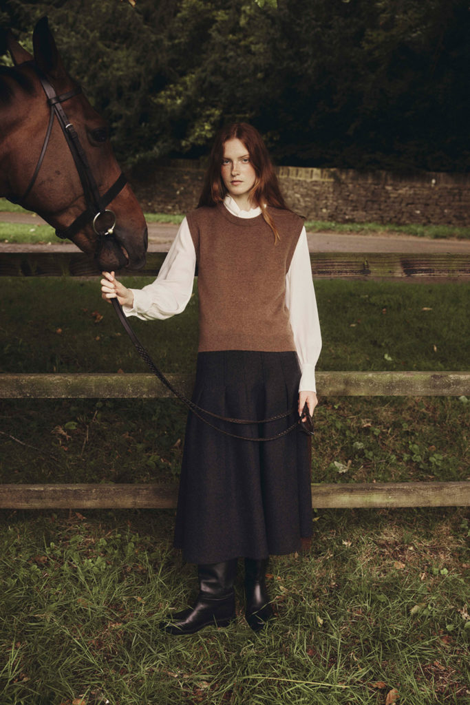 Woman wearing Bamford clothing holding reins of horse