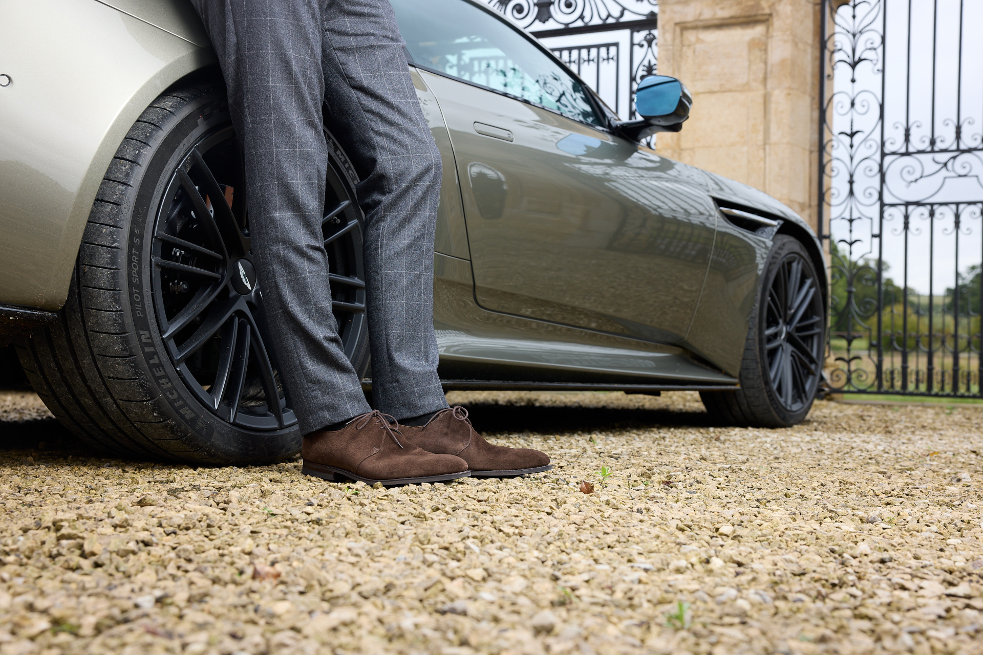 Close up of person leaning against car wearing Crockett & Jones x 007 shoes