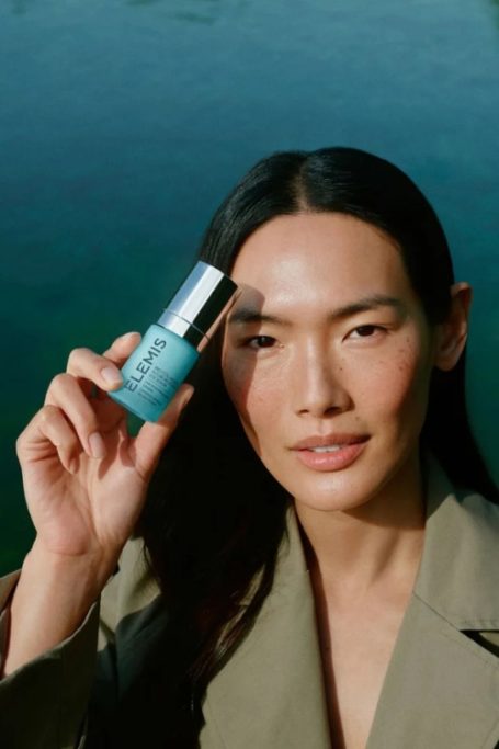 Woman holding Elemis bottle to her face
