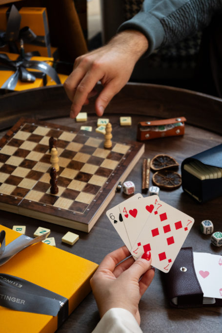 Boardgames laid out on table with people playing