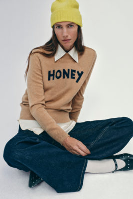 Woman in brown jumper, yellow and denim trousers