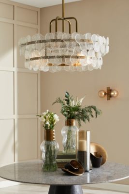 Side table with three vases and a gold chandelier above