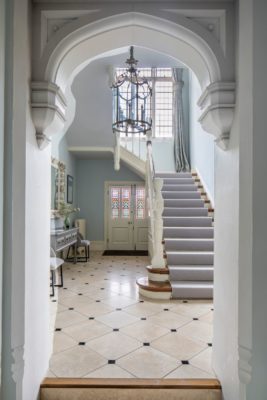 Hallway with tiled floors, a galleried landing and a chandelier