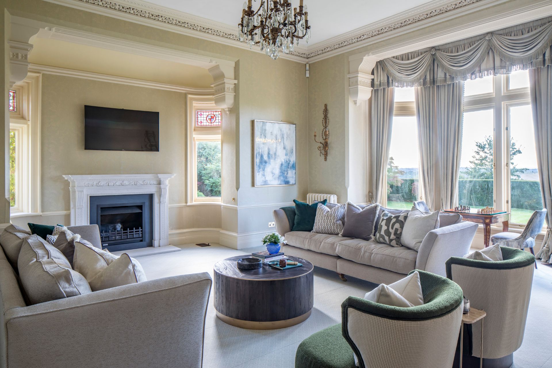 Living room with cream sofas, fireplace and chandelier