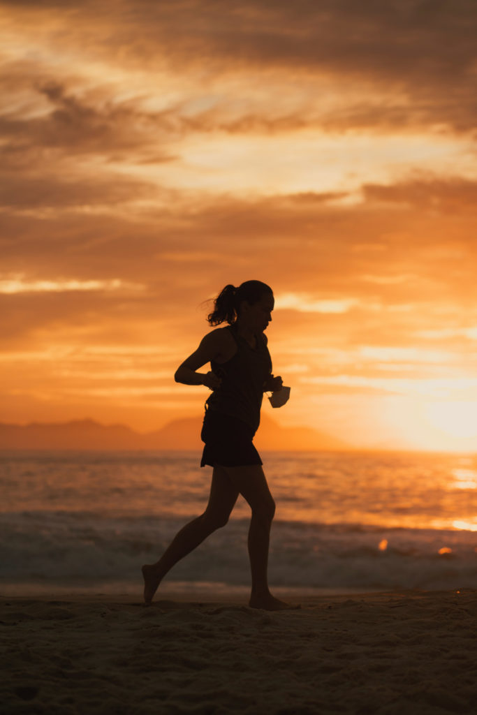Silhouette of woman running at sunset | Fitness Trends 2025
