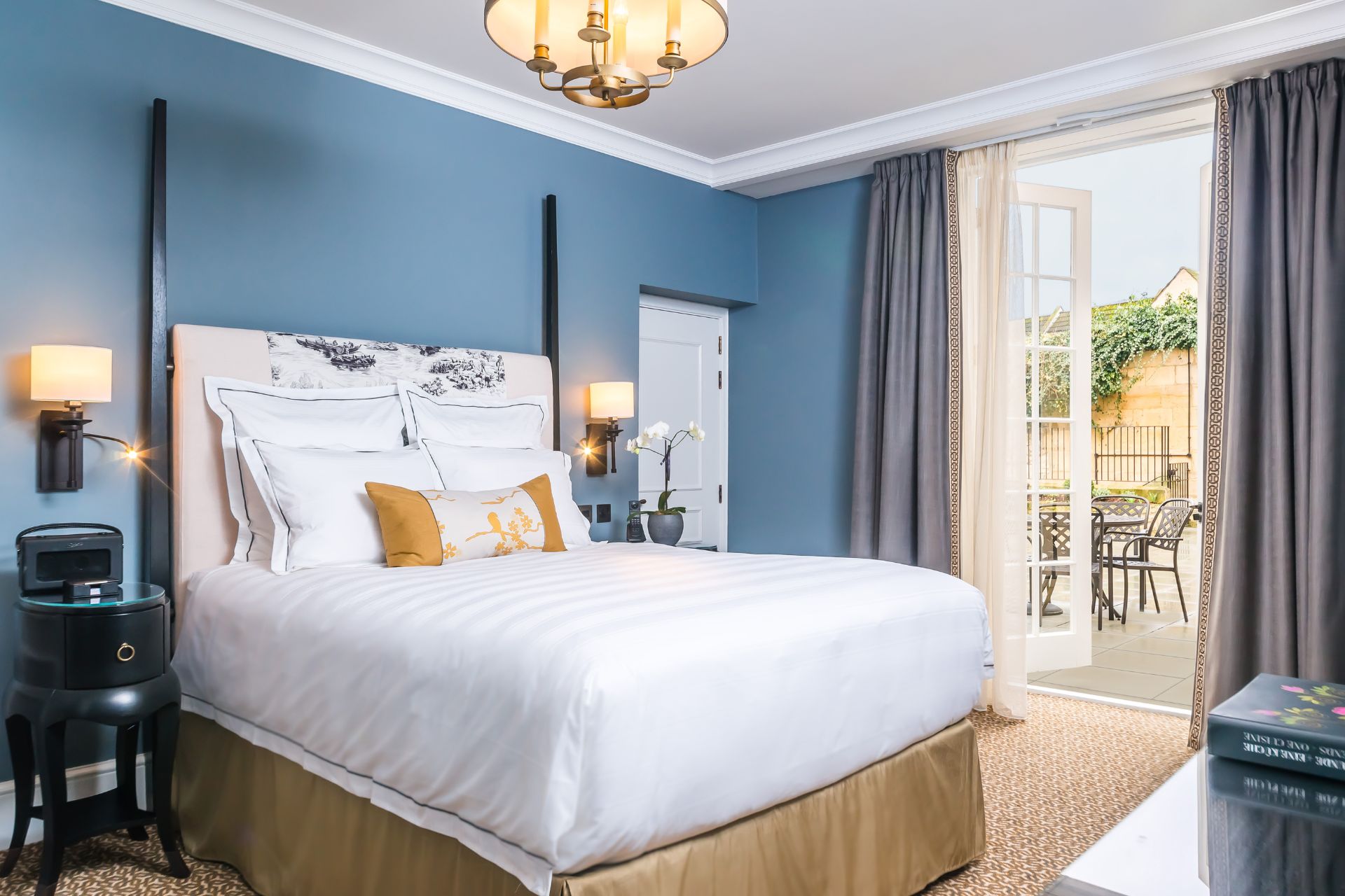 Hotel room with periwinkle blue walls and white linens