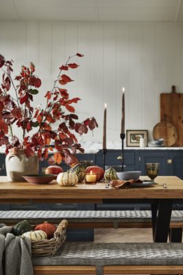 Autumna tablescape with orange leaves, candlesticks and pumpkins