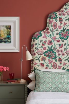 Pink floral patterned headboard in a raspberry-red bedroom