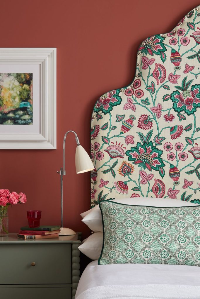 Pink floral patterned headboard in a raspberry-red bedroom