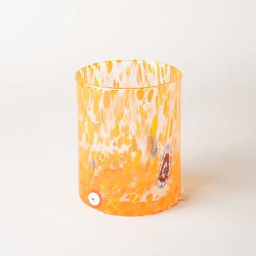 Glass tumbler with orange paint splatter design