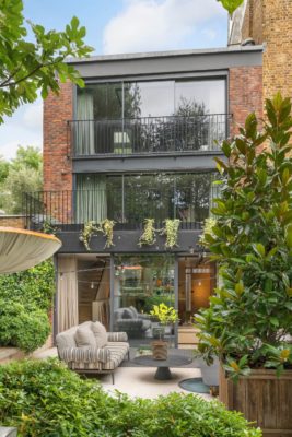 Exterior of modern home with floor-to-ceiling windows and black railings