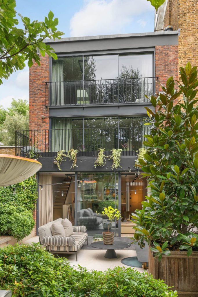 Exterior of modern home with floor-to-ceiling windows and black railings