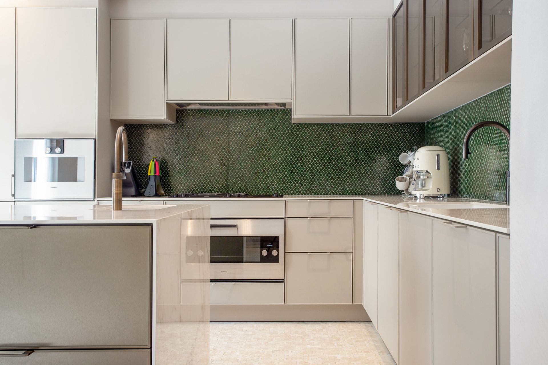 Kitchen with white marble worktops and a forest green tiled backsplash