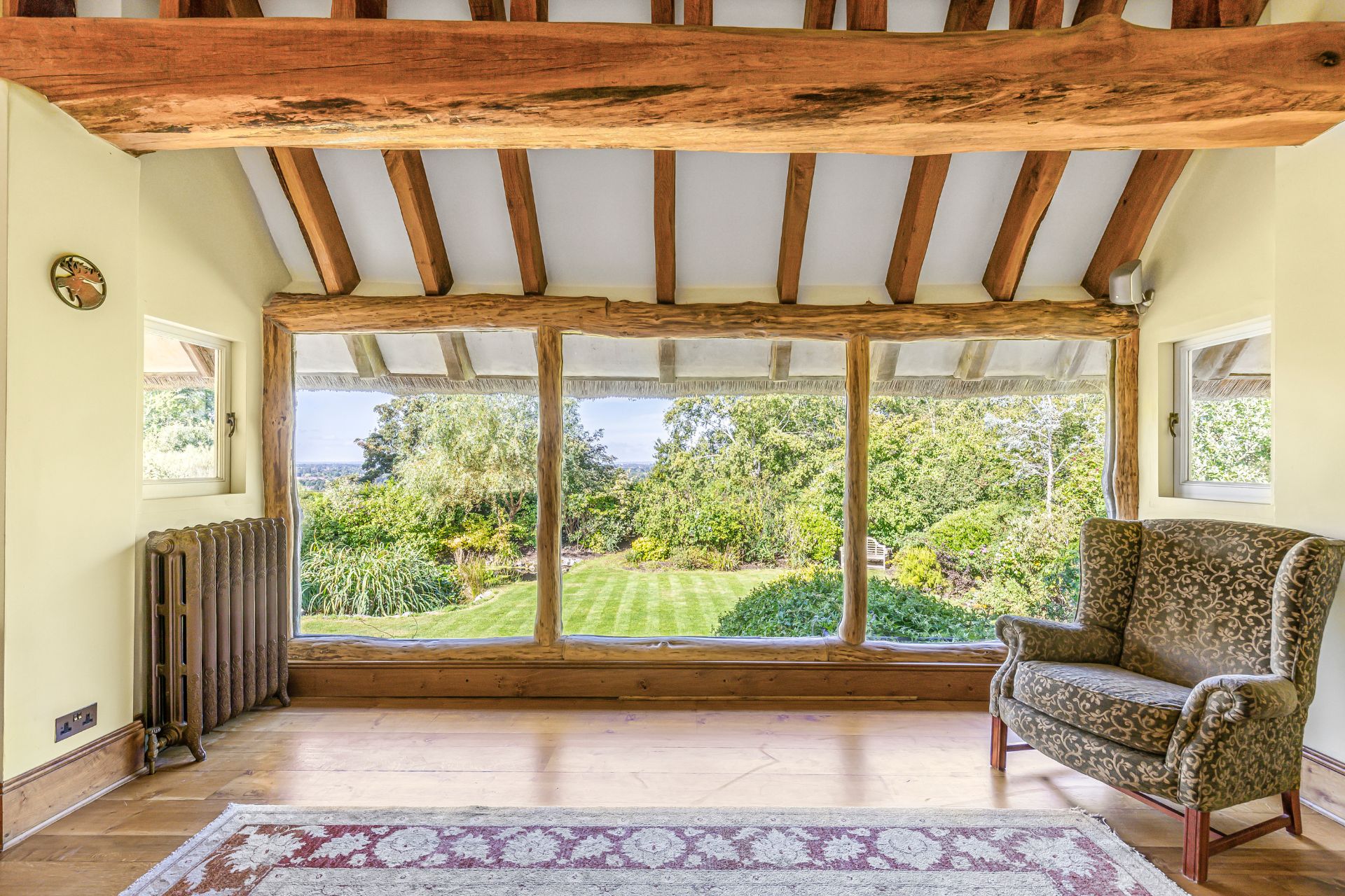 Living room with floor-to-ceiling windows overlooking a large garden