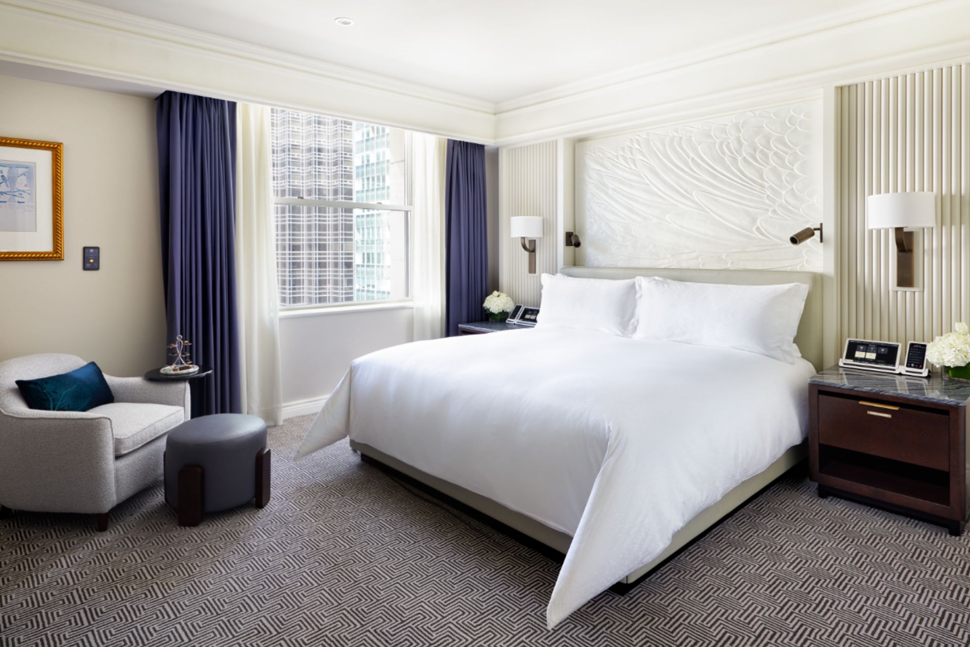 Hotel bedroom with navy curtains and white sheets