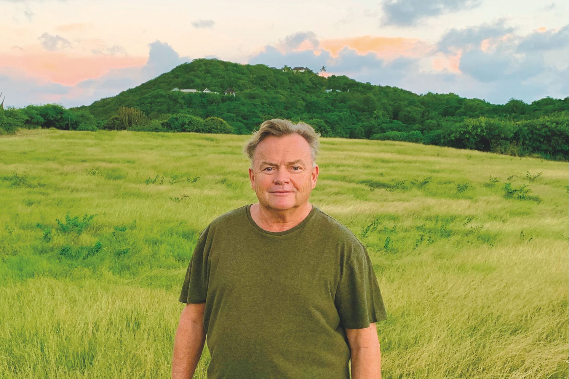 Roger Pritchard standing in a field at sunset