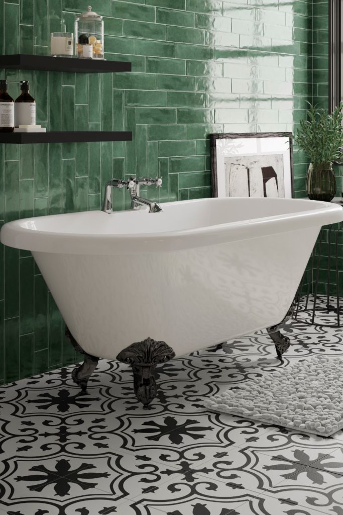 Dark green tiled bathroom with claw-foot bathtub and black and white tiles