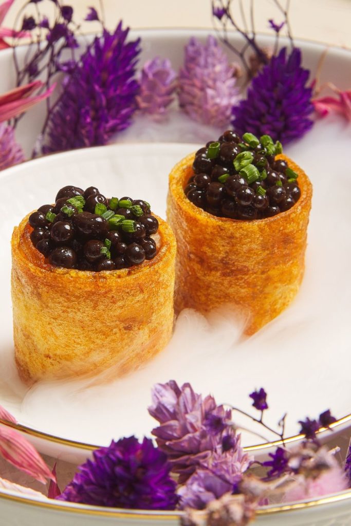 Two caviar vol au vents on a plate at Harrods' afternoon tea