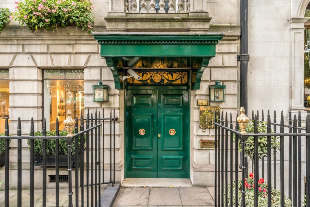 Mayfair apartment building with stone facade and green door.